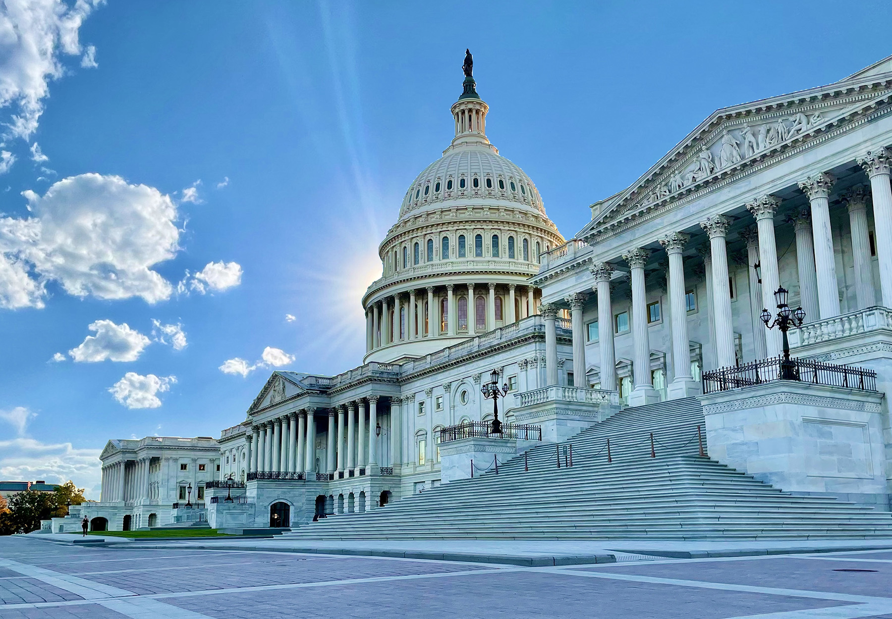 An image of the US Capitol Building in shadow with the sun behind it. iStock image.