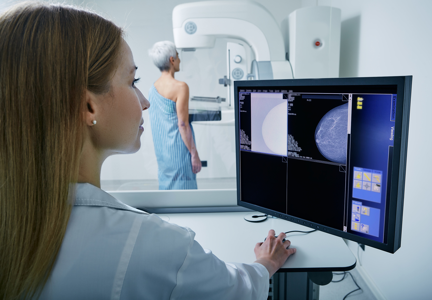 Mature woman undergoing breast screening or mammography by technician. iStock image.