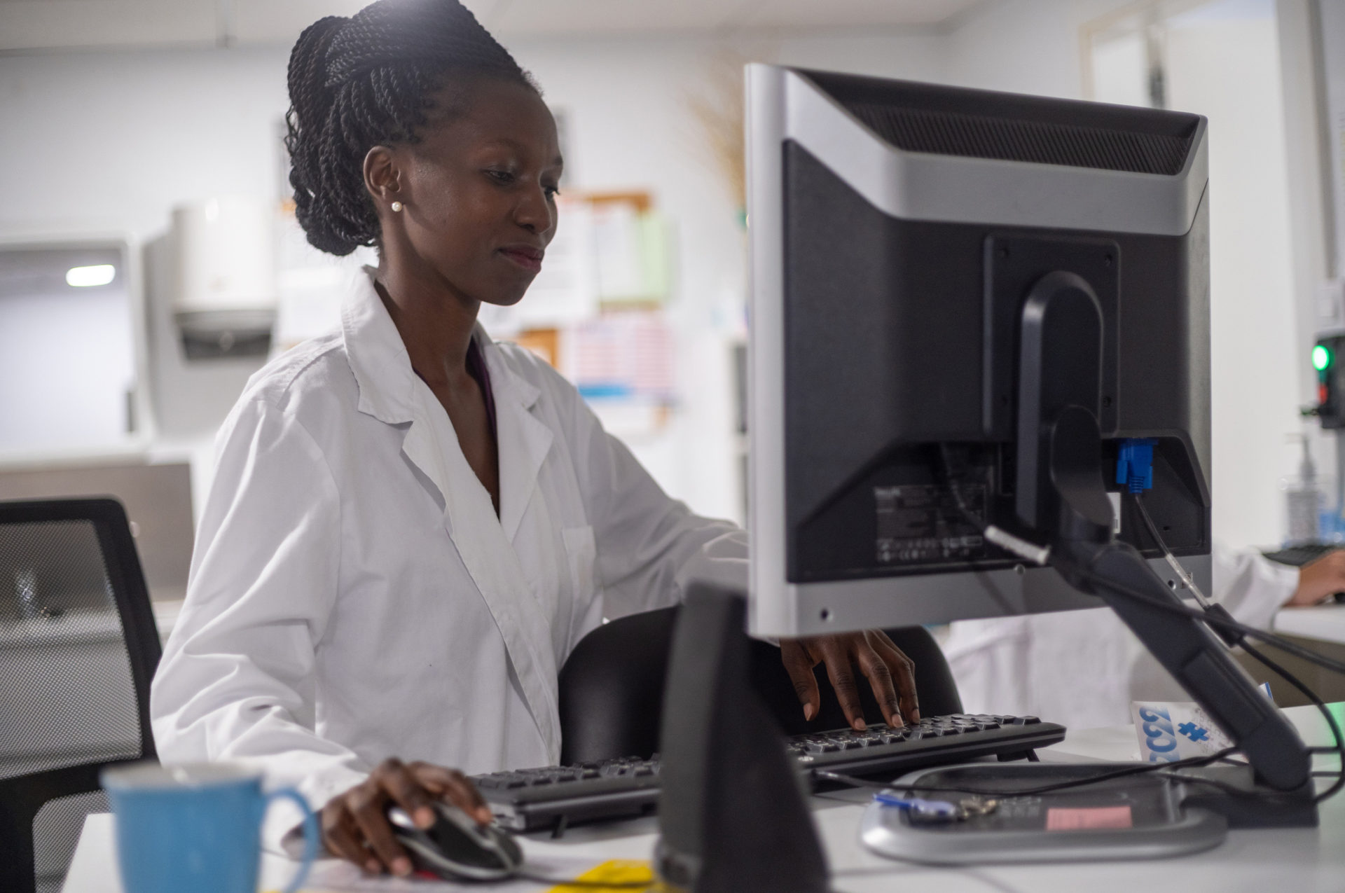 A young laboratory professional works on a computer in her office.