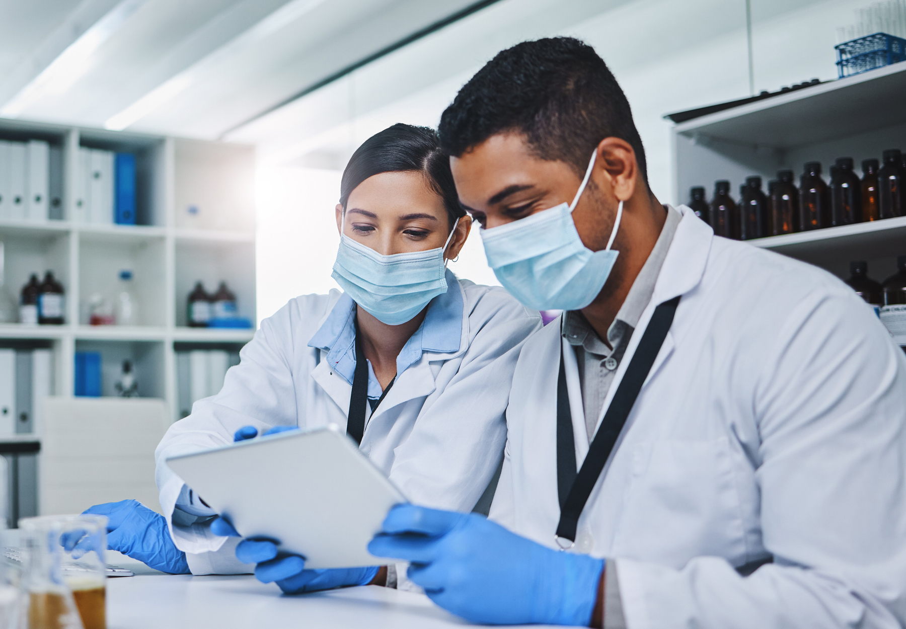 Two researchers in masks with gloves in a laboratory istock image