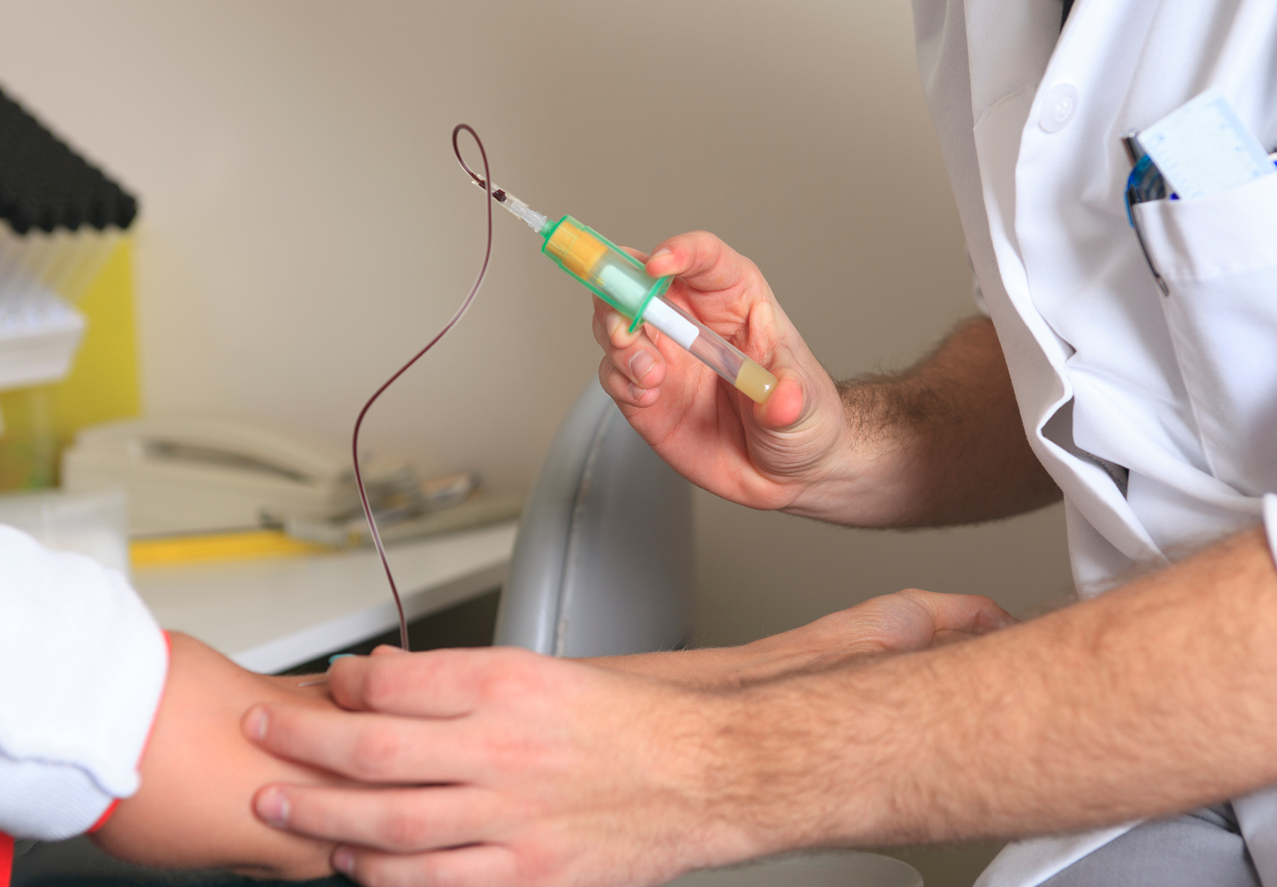 Medical practitioner taking blood sample from patient istock image