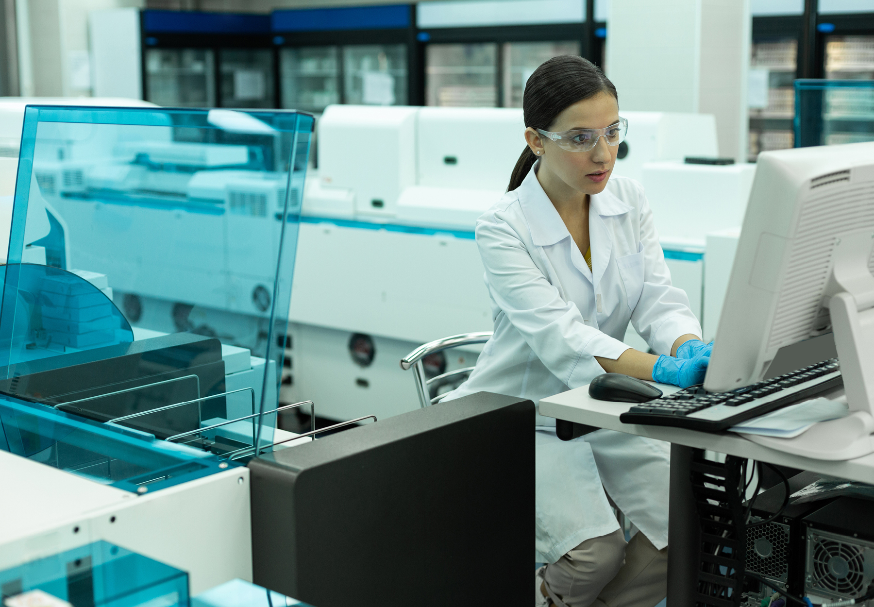 Female laboratory professional works on the computer in the lab. She has a worried look on her face. Stock image.