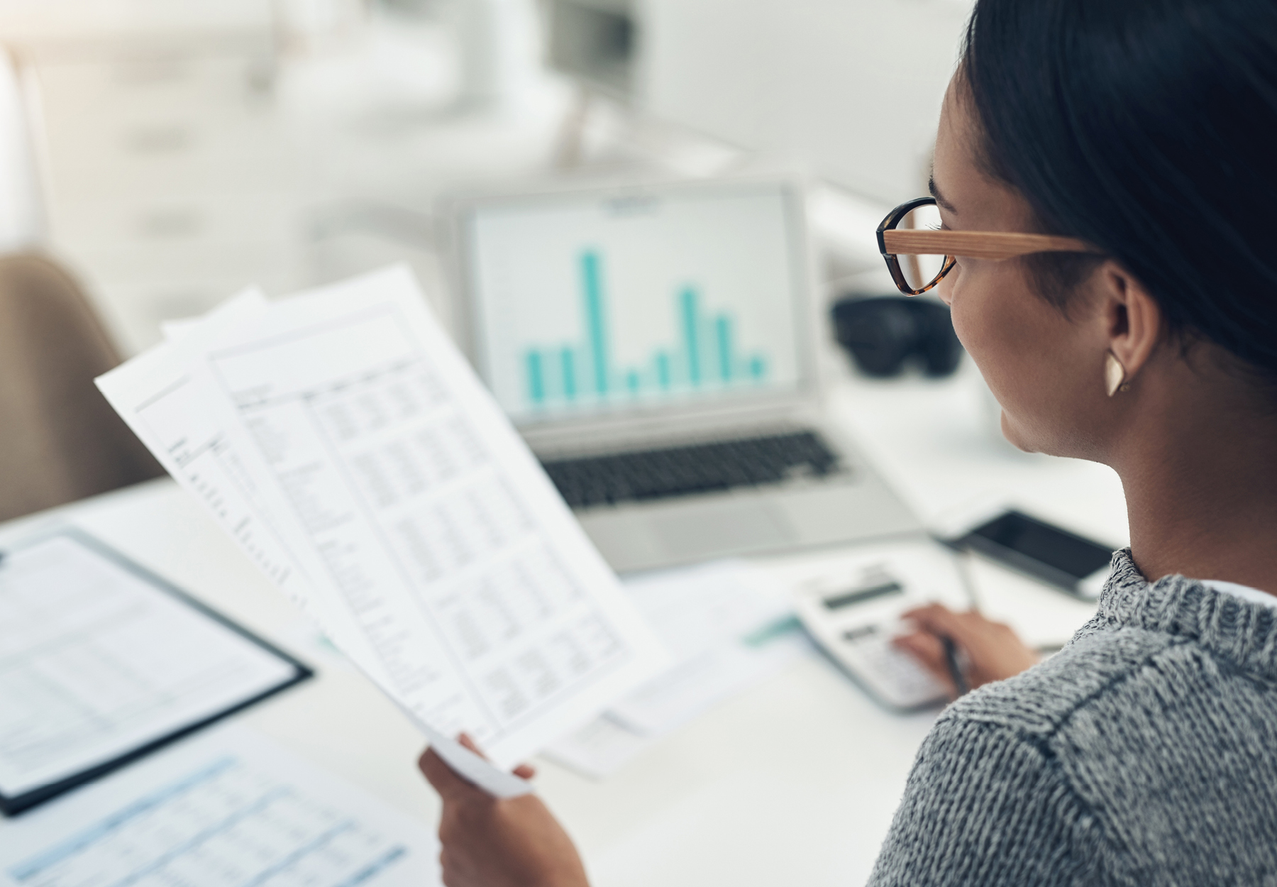 Closeup of female office worker examining paperwork at her desk.