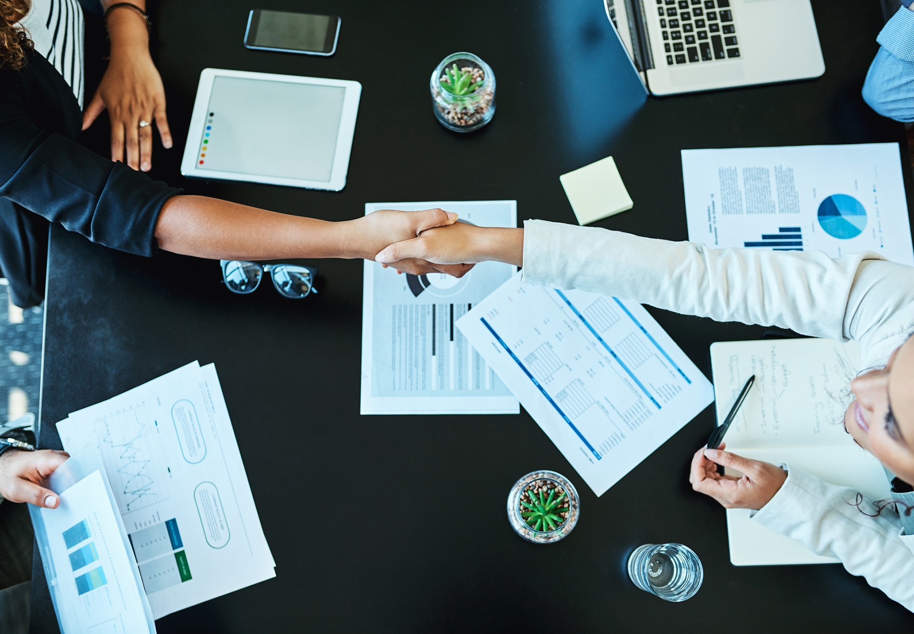 Closeup of businesspeople shaking hands during a meeting in an office. Business deal concept. Stock image.