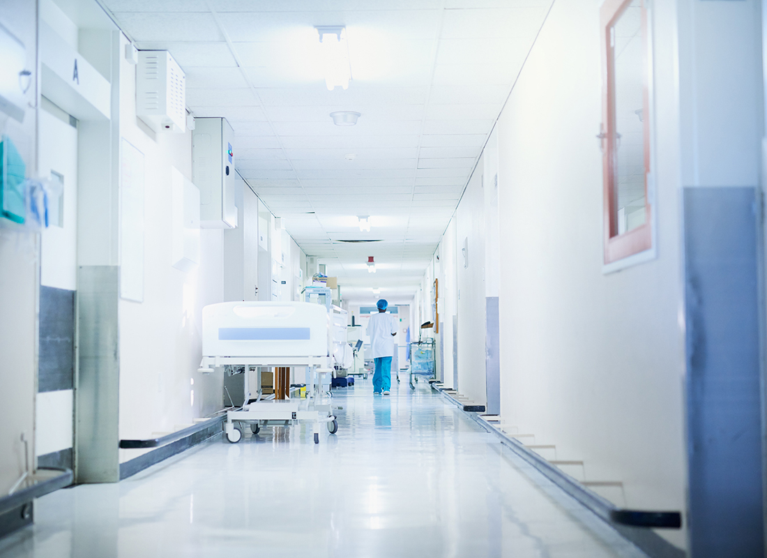 Rearview shot of a surgeon walking down a hospital corridor.