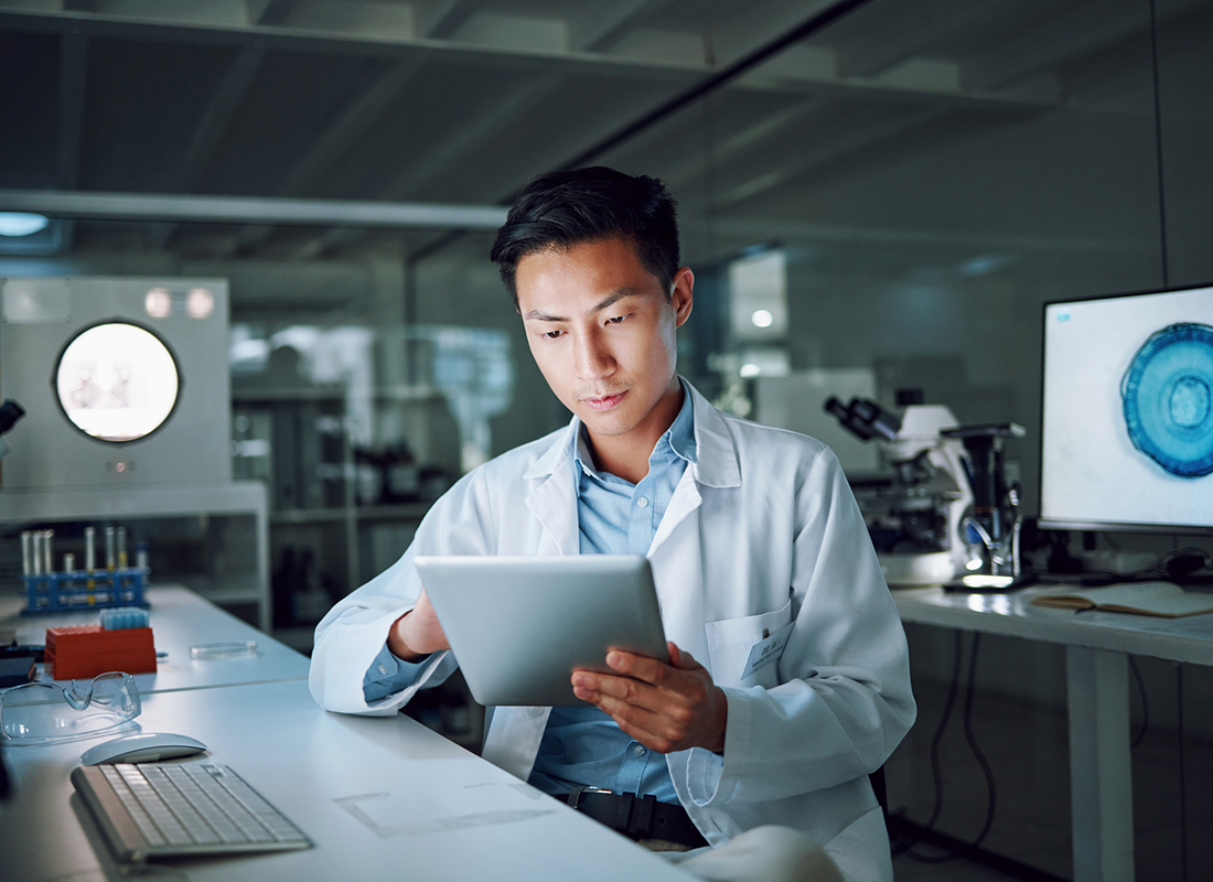 Male scientist of Asian descent looks at information on a tablet in the laboratory to illustrate the concept of new regulations for lab-developed tests.
