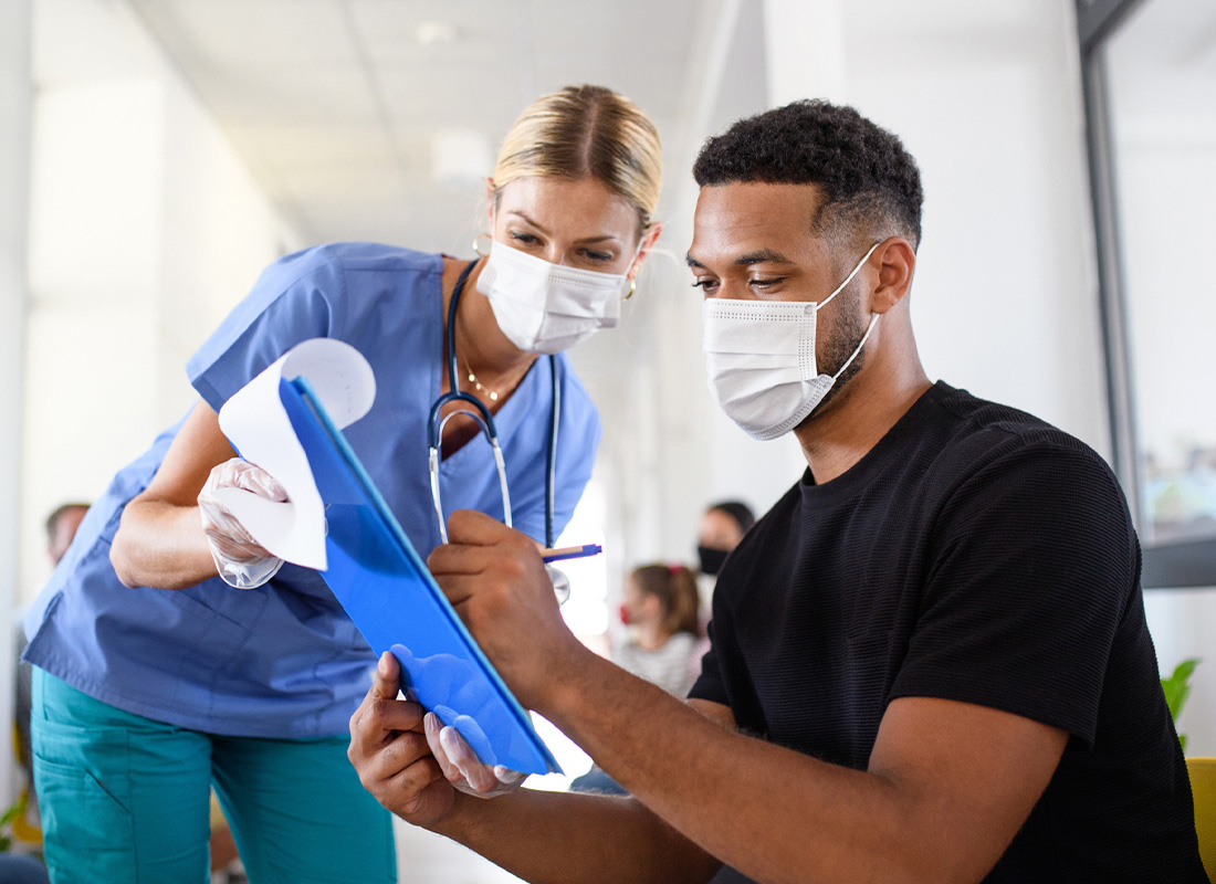 Nurse helps a patient with paperwork to illustrate the concept of clinical trials