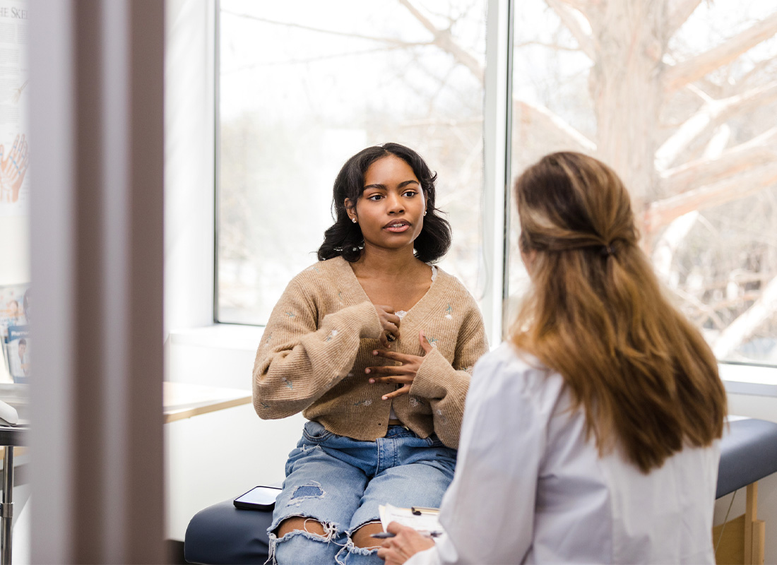 A young female patient meets with her doctor in the doctor’s office