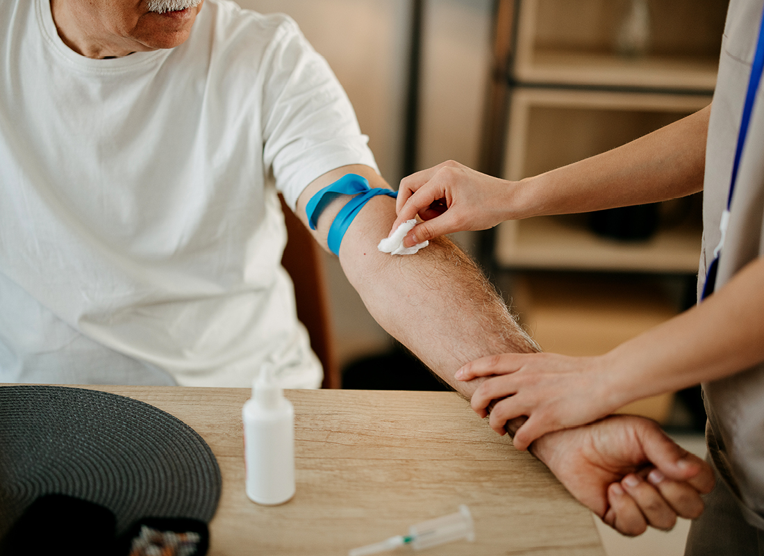 Phlebotomist preparing patient's arm for a blood draw